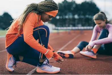 Enfants et adolescents se préparant sur une piste d'athlétisme avec chaussures Kalenji
